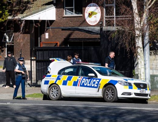 Armed police stand guard at the Hells Angels headquarters in Palmerston North while colleagues search the property. Credits: Stuff