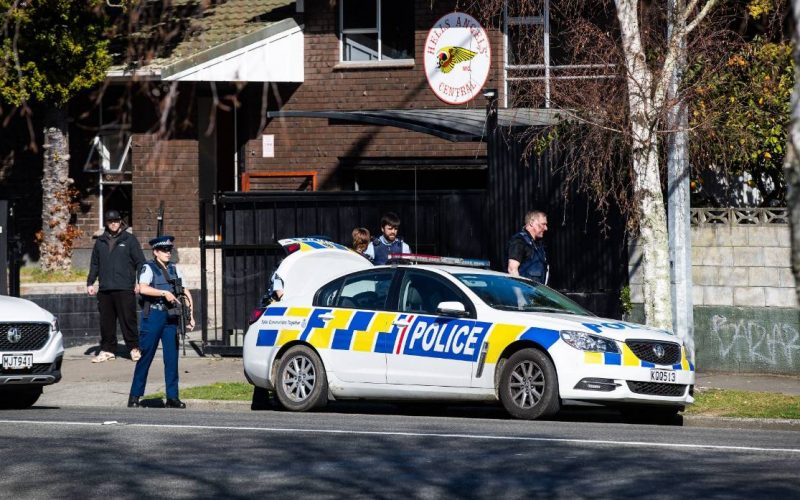 Armed police stand guard at the Hells Angels headquarters in Palmerston North while colleagues search the property. Credits: Stuff
