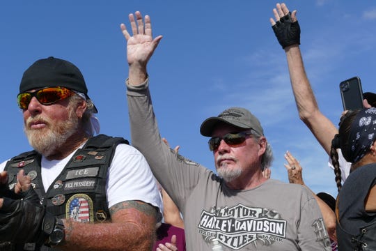 Vietnam war veterans raise their hand at the I-75 rest stop by exit 131 as hundreds of bikers set to escort The Wall That Heals from Fort Myers to Marco Island on Feb. 18, 2020.