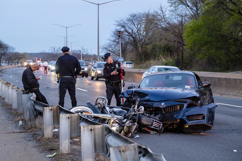 NYPD officers from the Collision Investigation Squad gather evidence at the scene where one of two cars racing on the Cross Island Parkway near Bell Boulevard in Bayside struck a motorcycle ridden by an off duty cop.