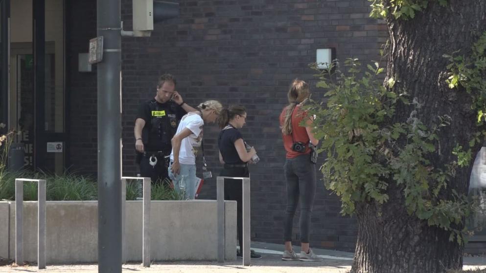 Police officers, press and onlookers stand in front of the office building in the Huchting district