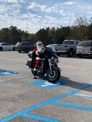 Santa visited children and their families before Christmas at the Wagon Branch Community Center. A local chapter of the Iron Order Motorcycle Club brought turkeys and all of the fixings to families at the center.